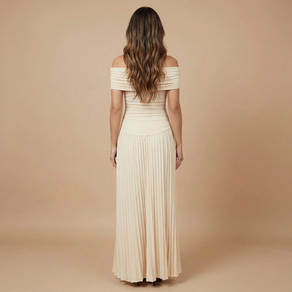Back view of cream maxi dress showing off-shoulder design and flowing pleated skirt