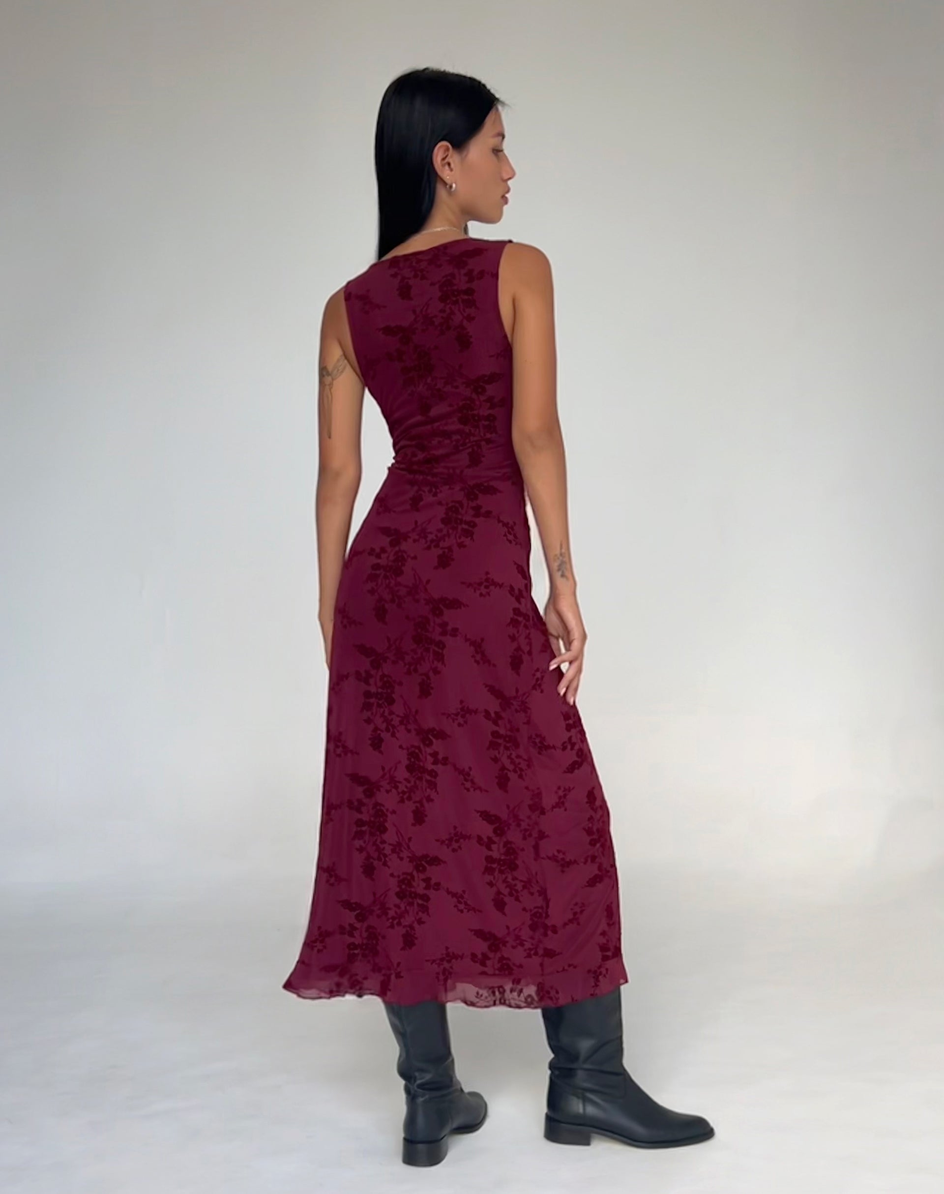 Back view of burgundy velvet midi dress with sleeveless design and floral pattern