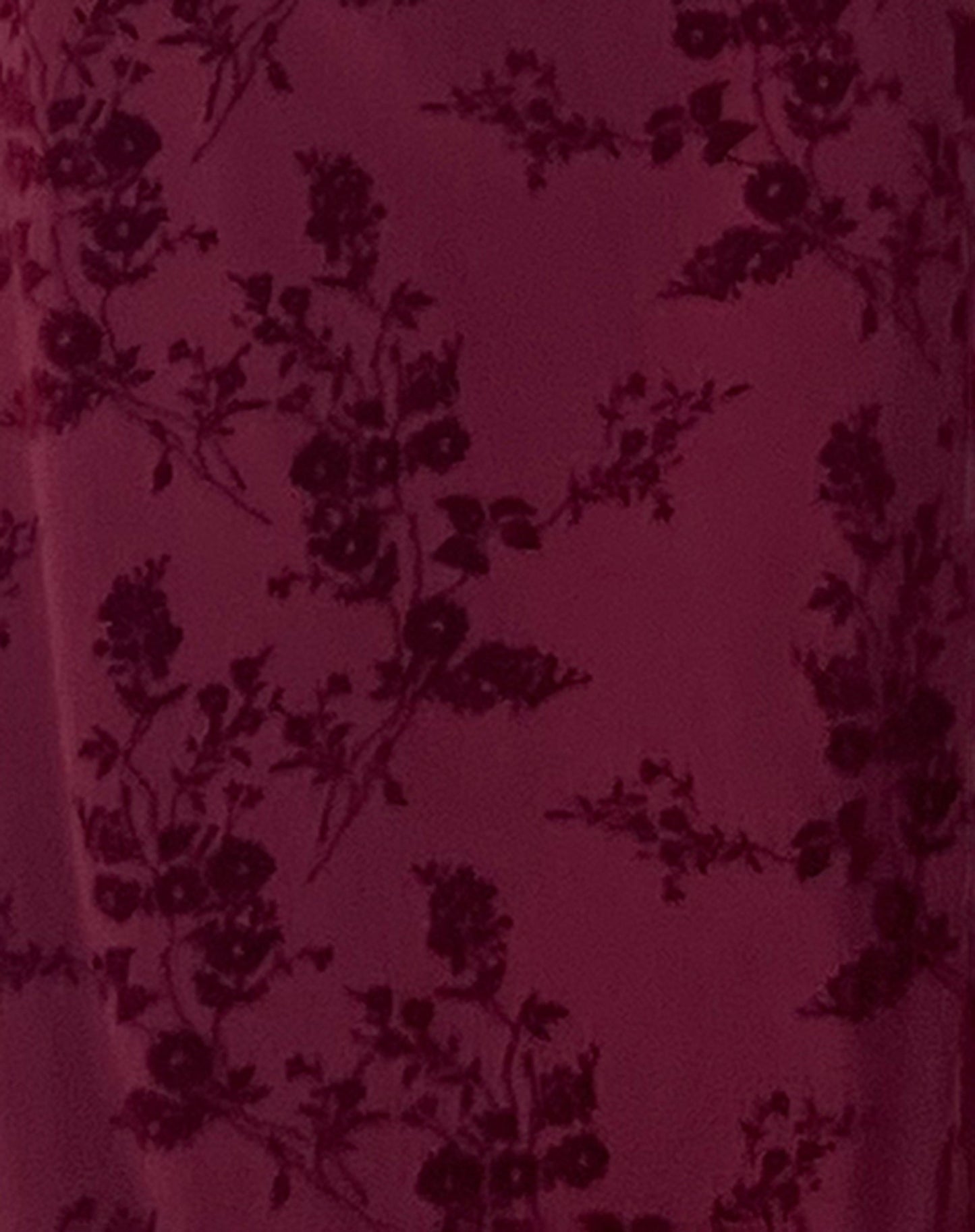 Burgundy velvet fabric close-up showing floral burnout design and texture detail