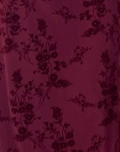 Burgundy velvet fabric close-up showing floral burnout design and texture detail