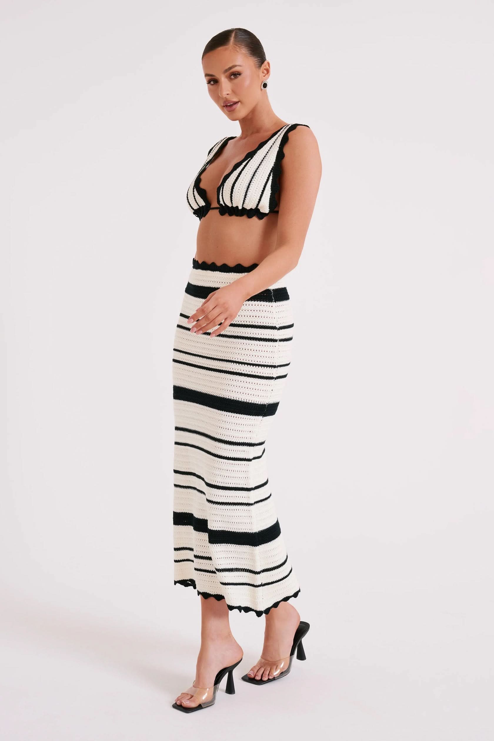 Side view of black and white striped two-piece midi set with textured knit