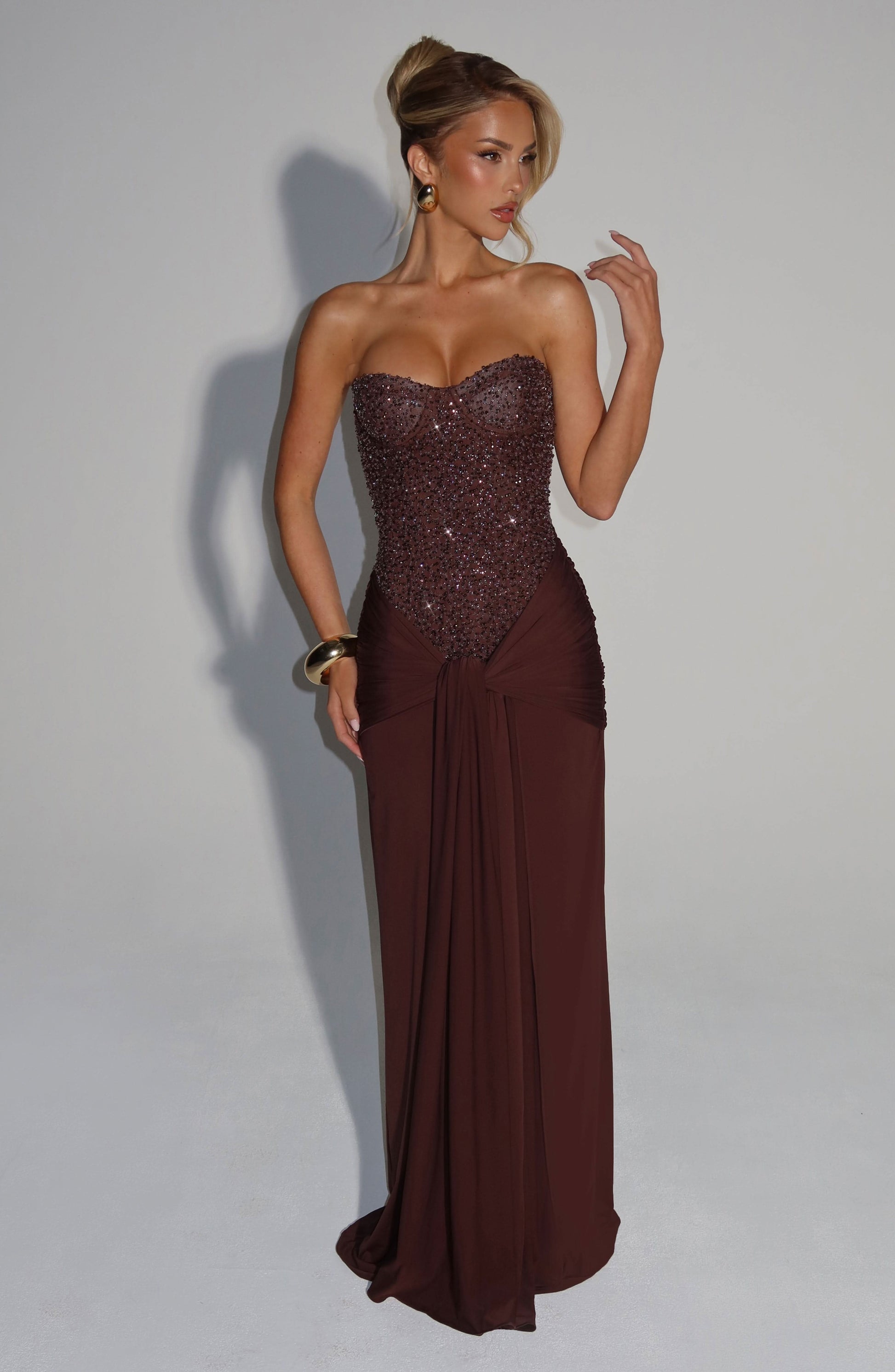 Side view of burgundy sequin strapless maxi dress