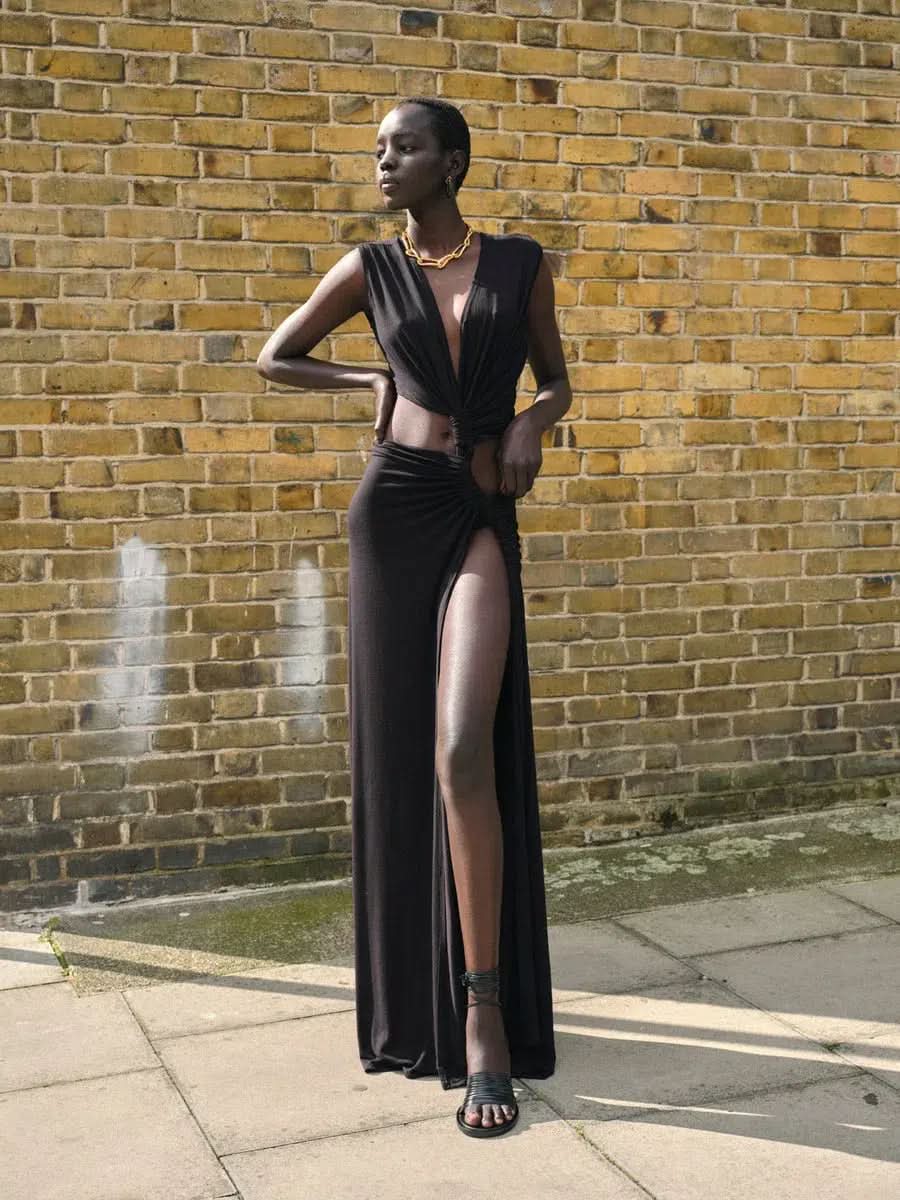 Black sleeveless maxi dress with waist cutout and high thigh slit