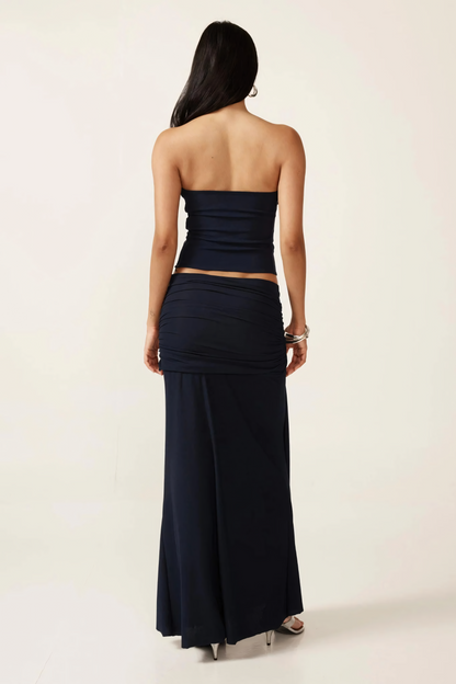 Back view of navy two-piece ruched set showing strapless crop top and floor-length skirt