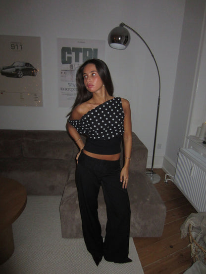 Back view of black polka dot crop top showing lace-up detail