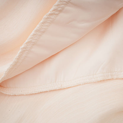 Cream ruffle mini dress hem with layered pleated fabric detail