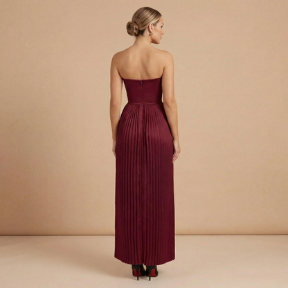Back of burgundy pleated maxi formal dress with fitted bodice and flowing ankle-length skirt