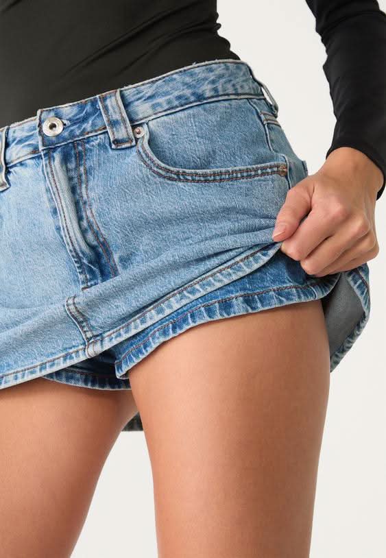 Close-up of light blue denim mini skort waistband and front pocket detail