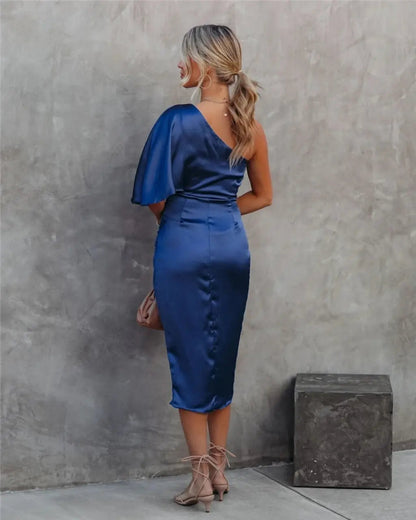 Front view of navy blue draped midi dress with dramatic one-shoulder cape and side slit detail