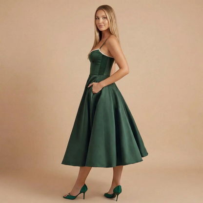 Side view of dark green midi dress with spaghetti straps and pocket detail