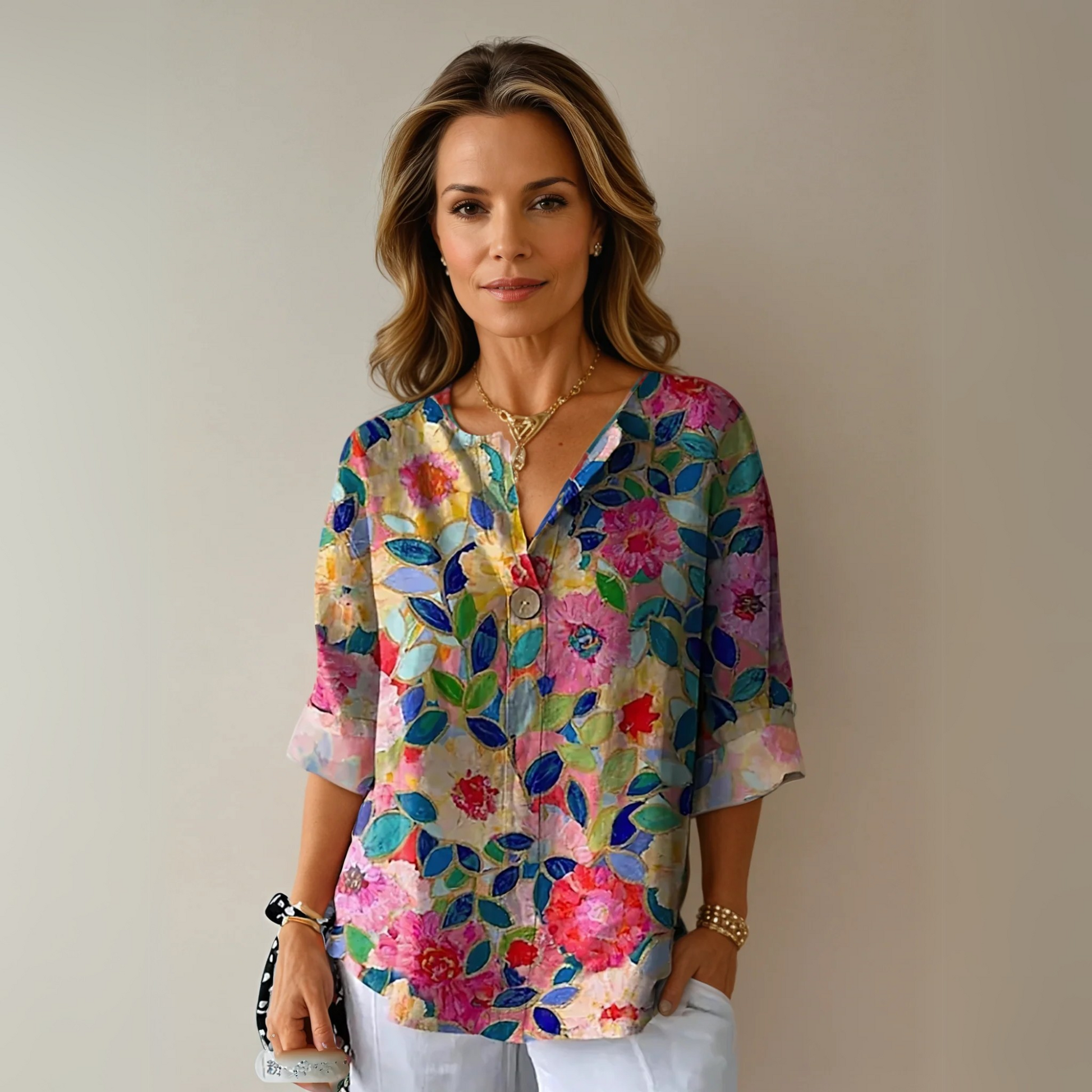 Multicolor floral 3/4 sleeve top with pink, red, yellow and blue blooms on neutral background