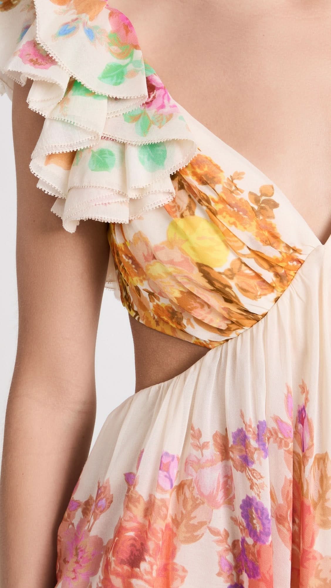 Close-up detail of ruffled sleeve and watercolor floral print on cream maxi dress