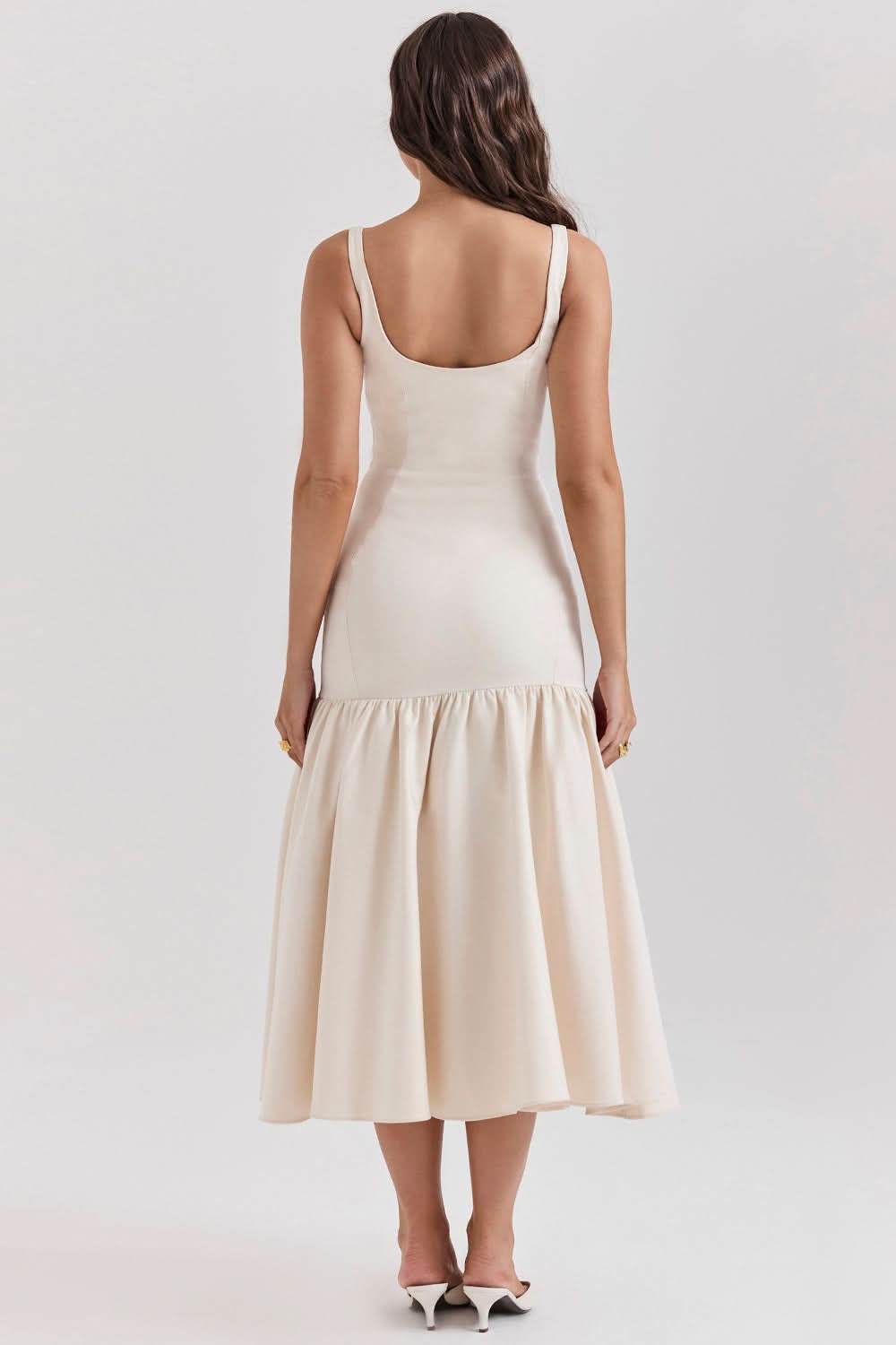 Cream sleeveless ruffle midi dress rear view showing fitted bodice and full hem