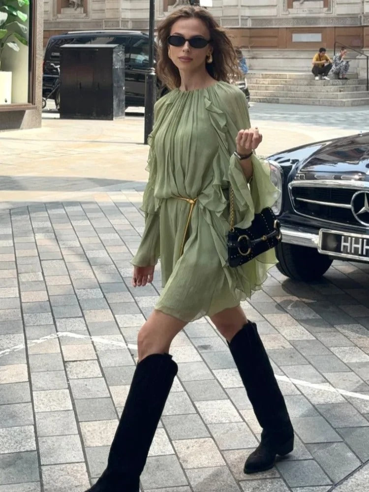 Sage green ruffle mini dress with ruffled sleeves styled with black boots