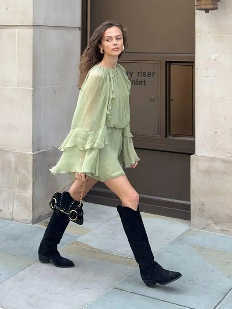 Sage green ruffle mini dress with layered ruffled sleeves, walking pose