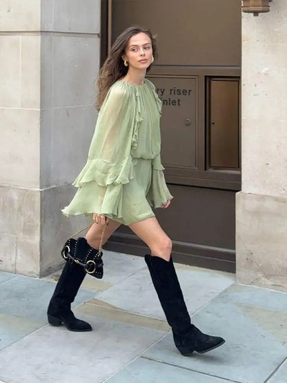 Sage green ruffle mini dress with layered ruffled sleeves, walking pose