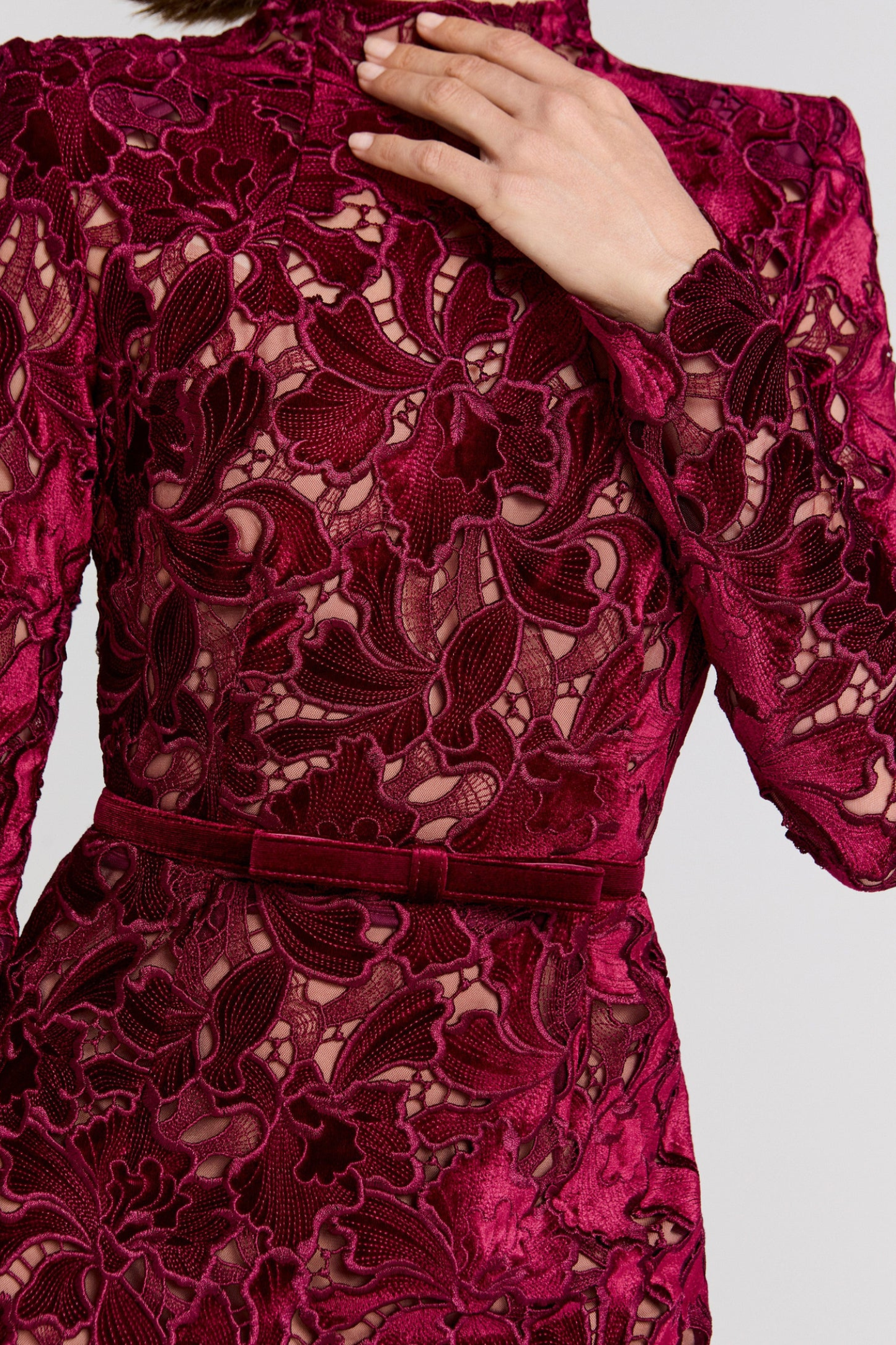 Close-up of burgundy lace texture and velvet waist belt detail