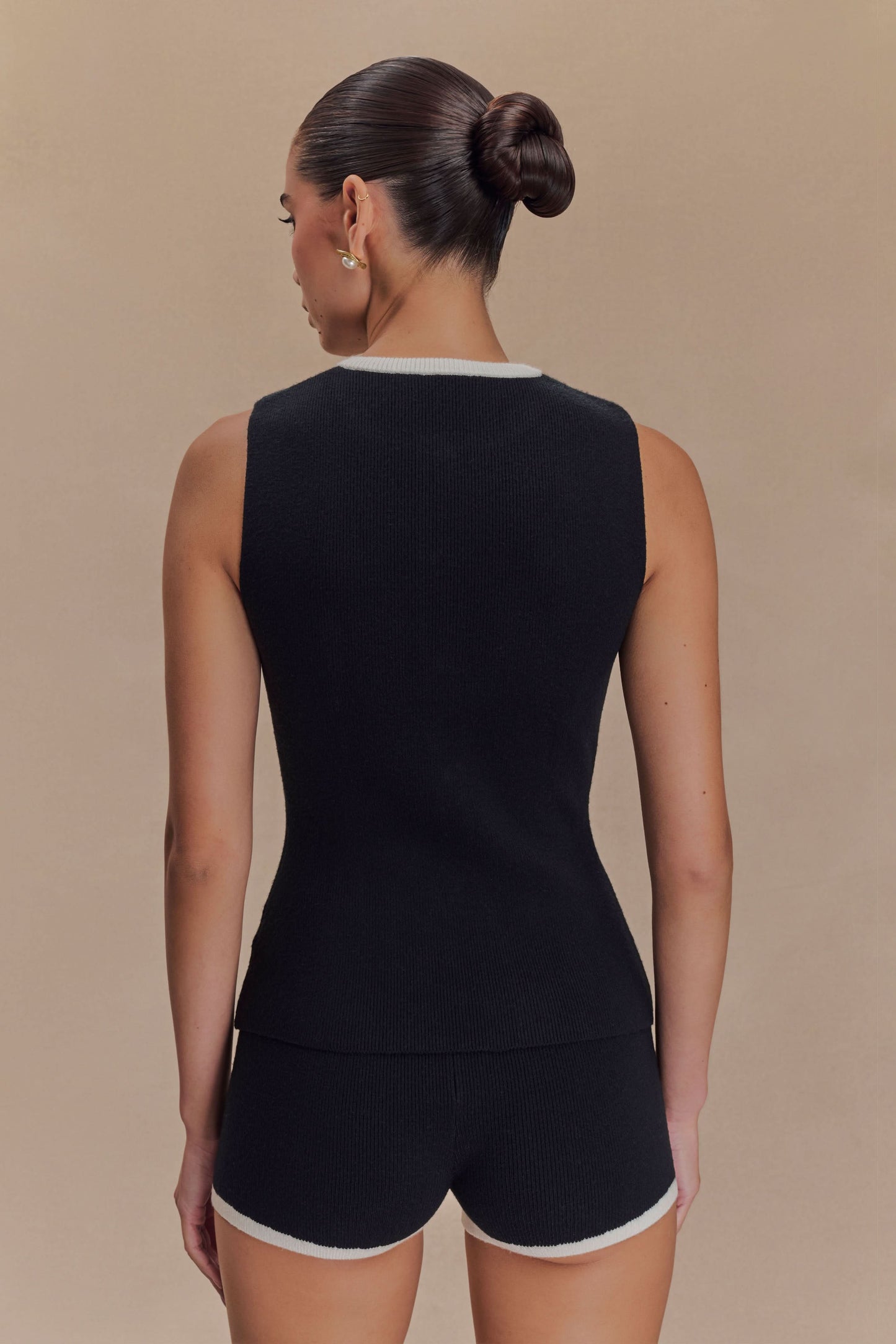 Back view of black ribbed knit tank top with white crew neckline