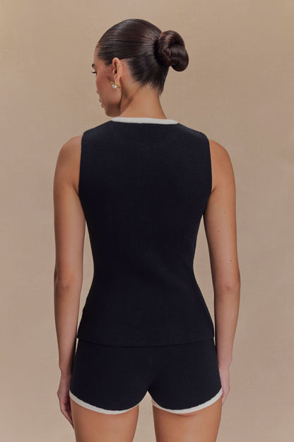 Back view of black ribbed knit tank top with white crew neckline