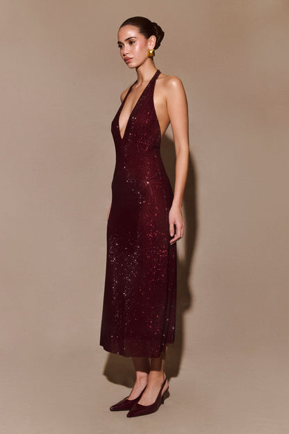 Side view of burgundy sequined halter dress with backless design