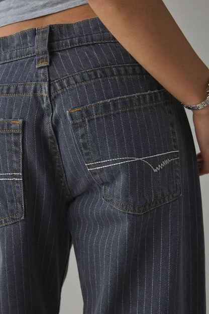 Close-up of back pocket on dark indigo pinstripe denim with decorative stitching detail