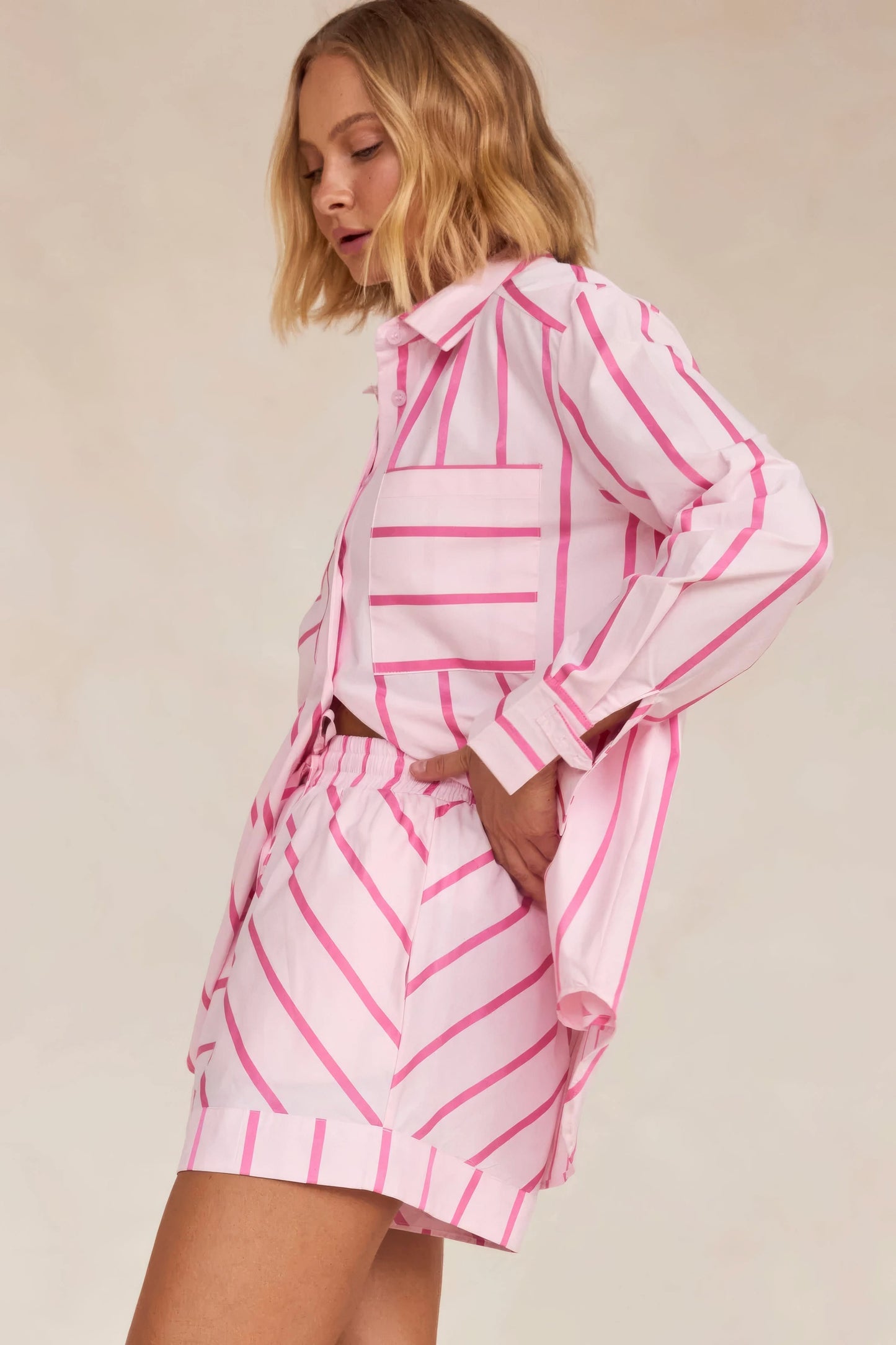 Back view of pink striped shirt showing geometric pattern and pleated shorts