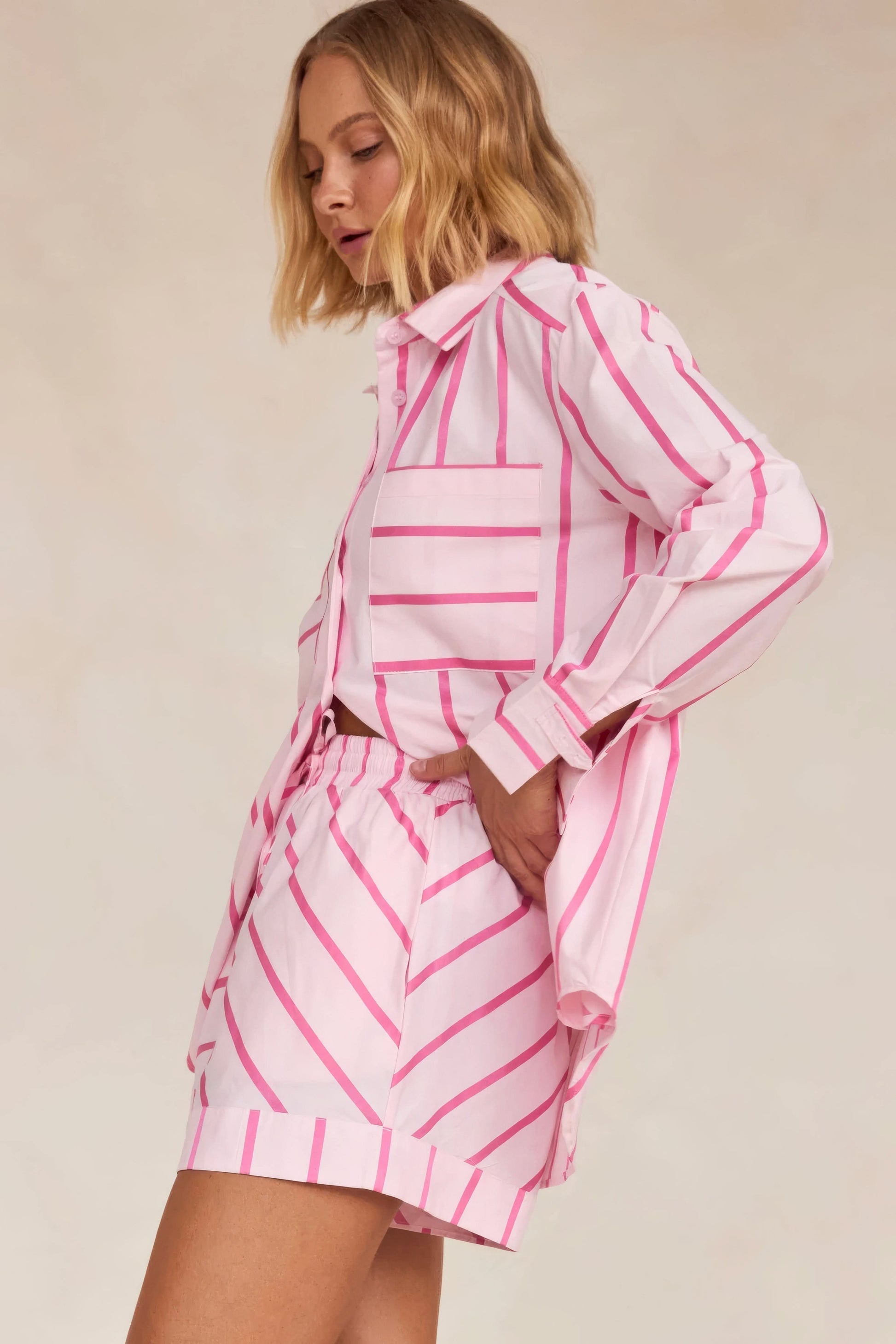 Back view of pink striped shirt showing geometric pattern and pleated shorts