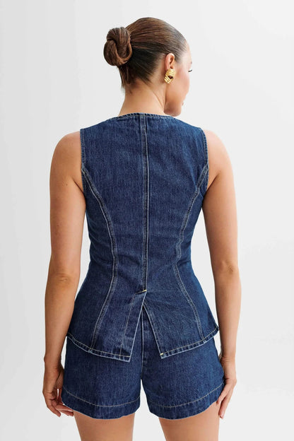 Back view of blue denim vest showing seamed construction and shorts