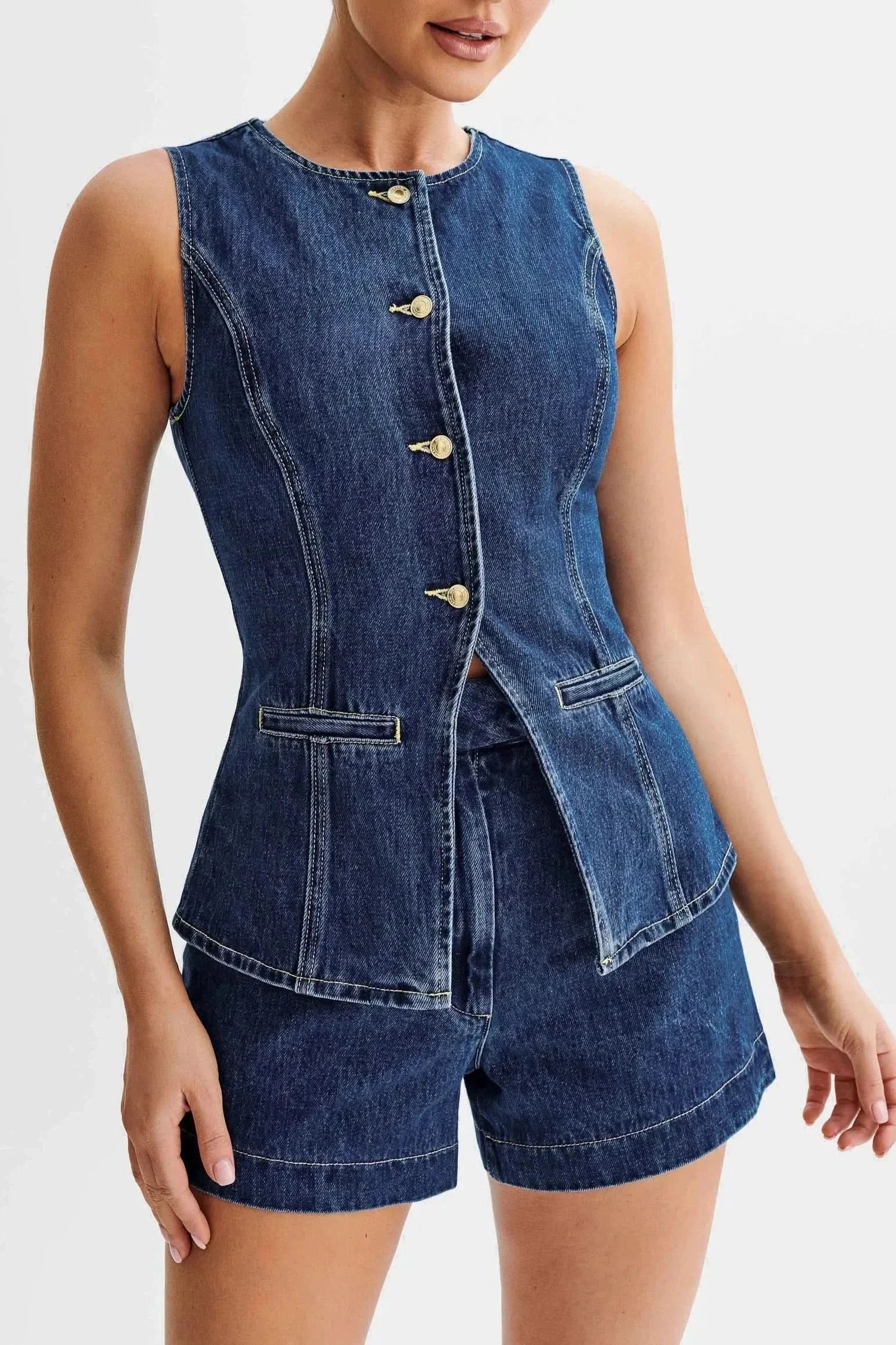 Detail view of blue denim vest with peplum hem and gold buttons