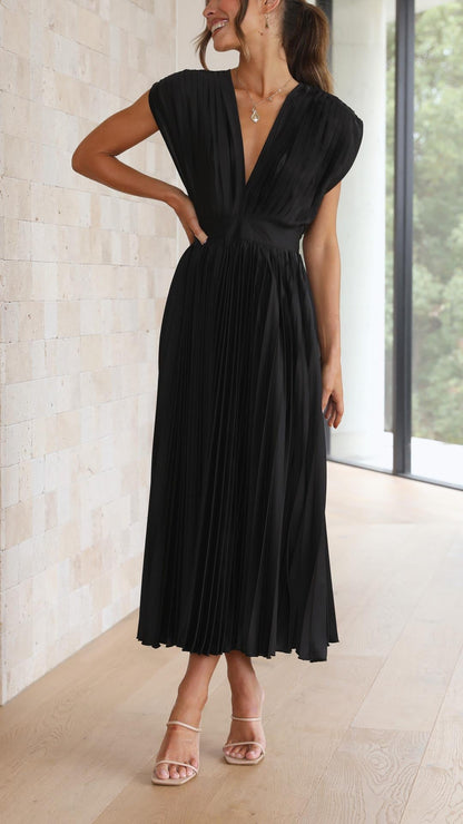 Side view of black pleated midi dress with gathered waist