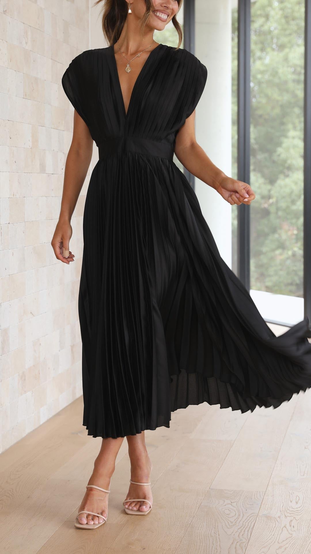 Back view of black pleated midi dress with tie closure
