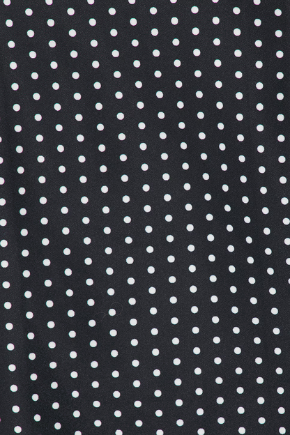 White polka dot pattern detail on black fabric of mini dress