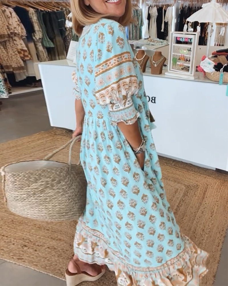 Back view of light blue floral maxi dress with decorative bands and tiered hem