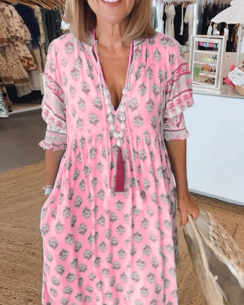 Pink tiered maxi dress with gray floral print and tassel tie neckline