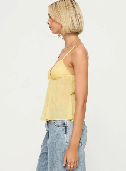 Side profile of pale yellow pleated cami with lace bust