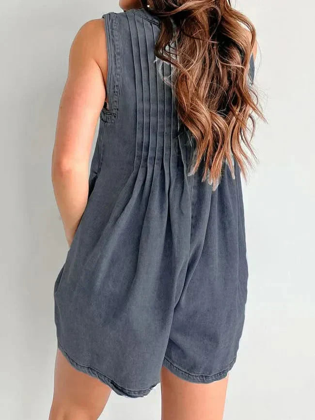 Blue denim romper back view with vertical pleating and relaxed fit