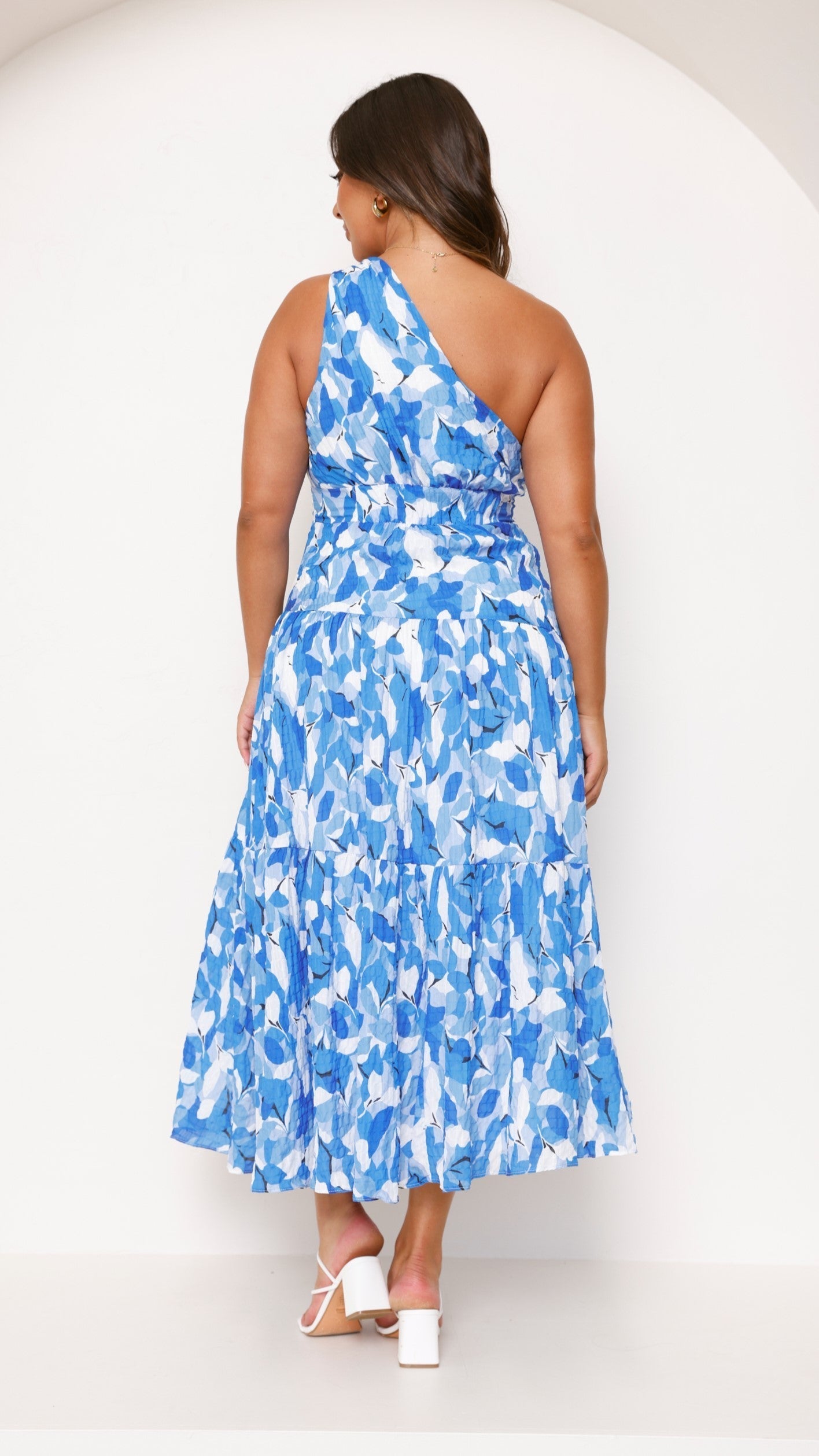 Back view of blue abstract tiered midi dress with layered skirt
