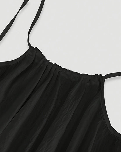 Close-up of black maxi dress neckline with pleated bodice detail