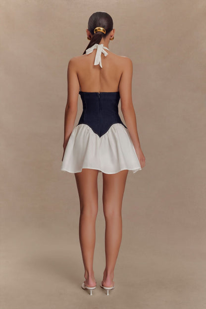 Back view of navy corset mini dress with white halter ties and full skirt