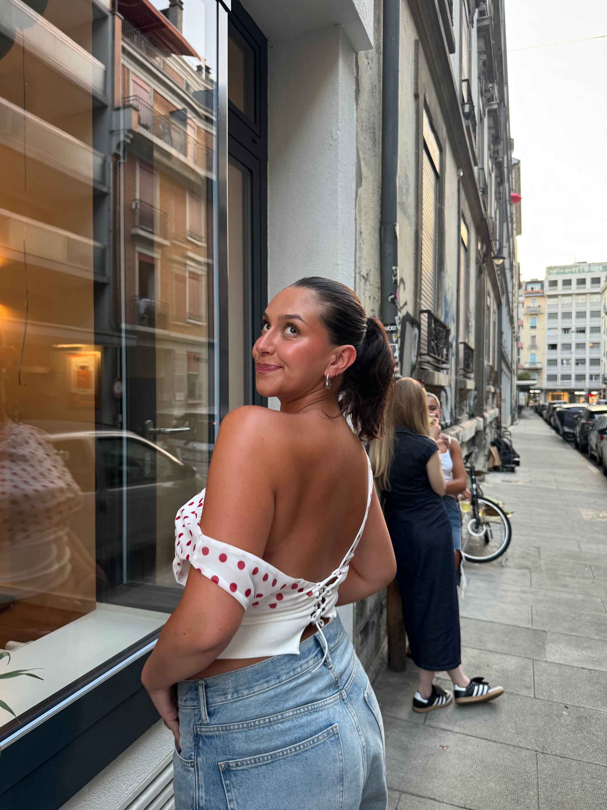 Red polka dot crop top with off-shoulder drape and white trim detail