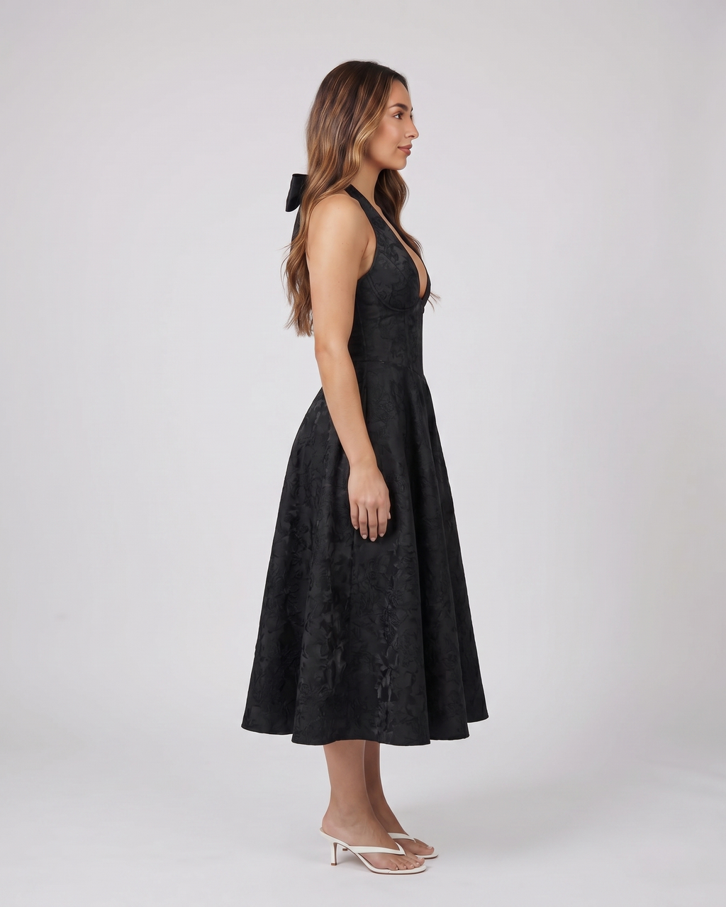 Side view of black floral jacquard halter midi dress