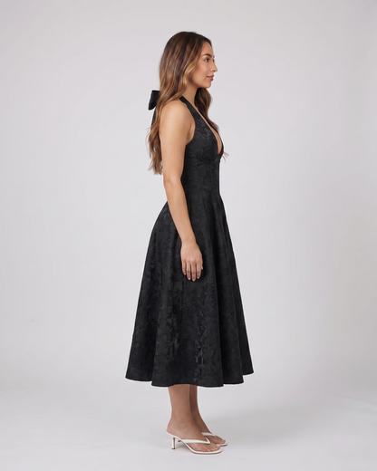 Side view of black floral jacquard halter midi dress