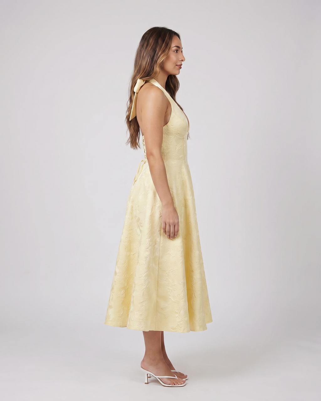 Side view of yellow floral jacquard halter midi dress