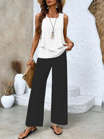 White sleeveless layered top with black wide-leg pants