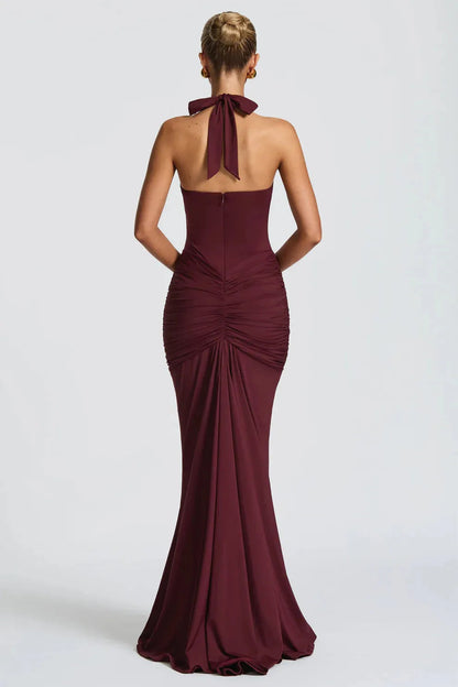 Back view of burgundy ruched maxi dress with halter tie and mermaid hem