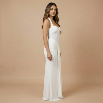 Cream ruched maxi dress side view displaying gathered waist and floor-length silhouette