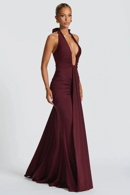 Side view of burgundy halter ruched maxi dress with fitted bodice