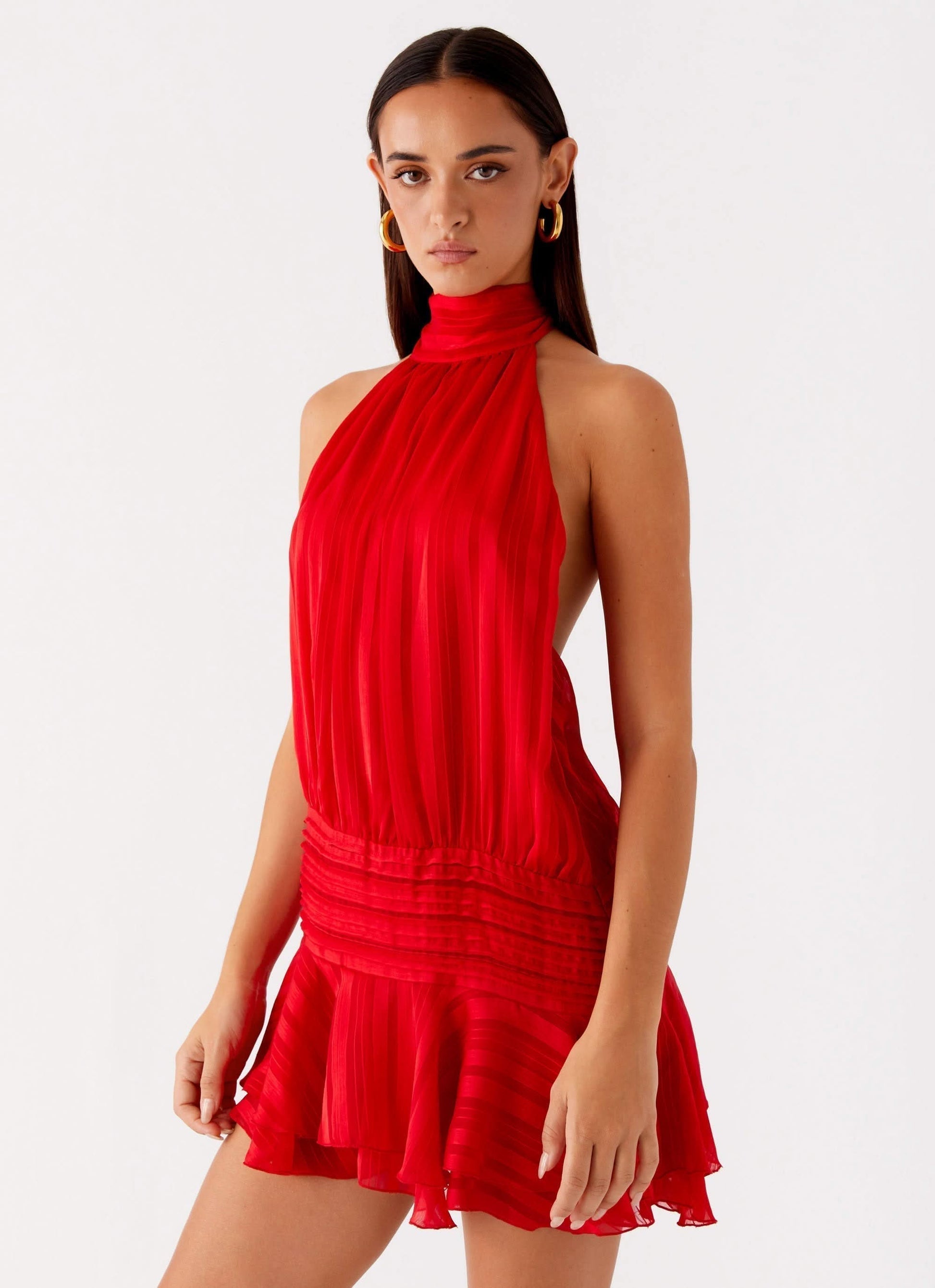 Bright red pleated halter mini dress with cinched waist and tiered ruffle skirt