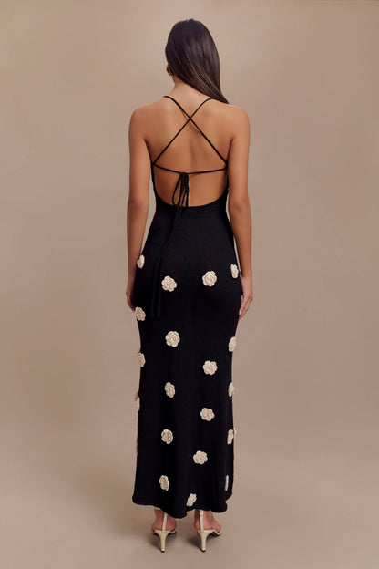 Back view of black maxi dress with crisscross straps and floral embellishments