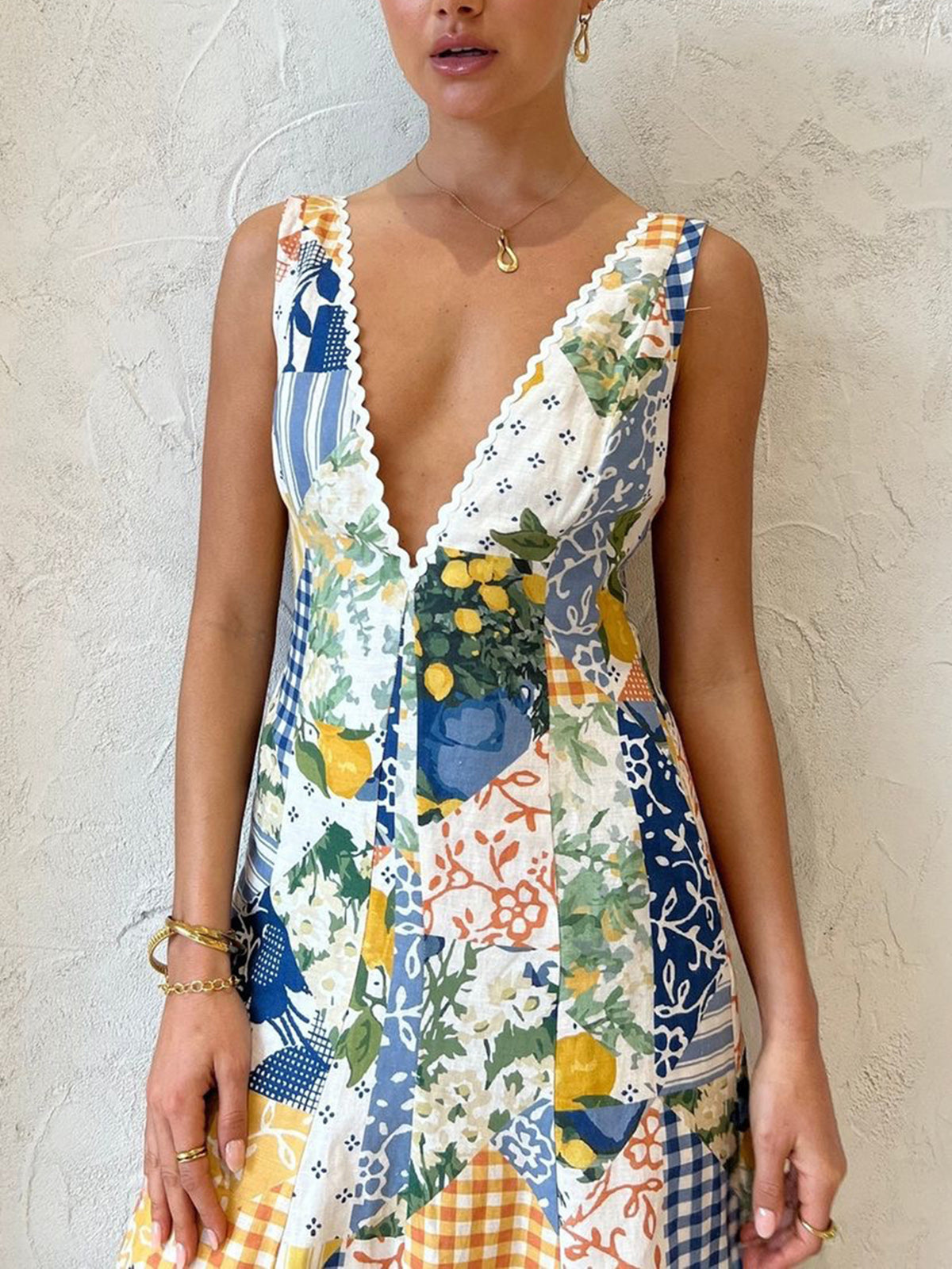 Close-up of deep V-neckline with scalloped trim on patchwork floral maxi dress